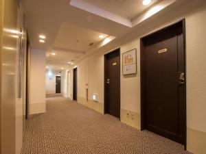 a hallway with black doors and a tile floor at Hearton Hotel Shinsaibashi in Osaka +52 photos