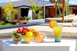 a table topped with bowls of fruit and a drink at Eden Appartel in Koné