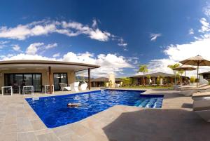 a swimming pool with chairs and a house at Eden Appartel in Koné