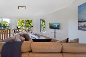uma sala de estar com um sofá e uma mesa em Advance Place em Sunrise Beach