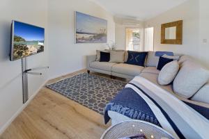 a living room with a couch and a tv at Advance Place in Sunrise Beach