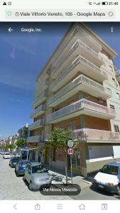 a building with cars parked in front of it at Grattacielo alla Stazione in Sannicandro Garganico