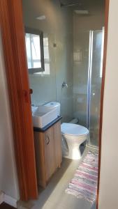 uma casa de banho com um WC, um lavatório e um chuveiro em Beachway Guesthouse em Port Elizabeth