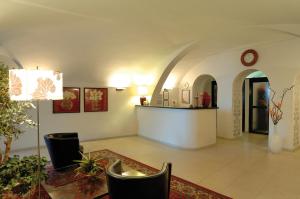 - un salon avec une table, des chaises et une horloge dans l'établissement Residence Le Terrazze, à Alassio