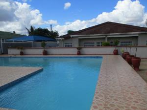 a swimming pool in front of a house at Avon Apartments in Lilongwe