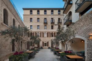 an alleyway with tables and chairs in front of a building at The Setai Tel Aviv, a Member of the leading hotels of the world in Tel Aviv