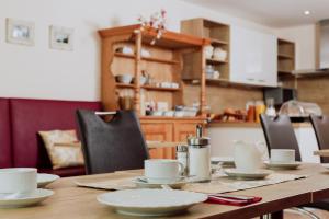 een houten tafel met witte gerechten erop bij Gästehaus Hötzl in Galgweis