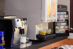 山形市Hotel Sakuranbo的一台咖啡机和两杯橙汁