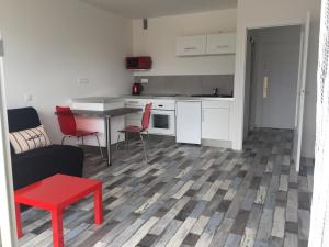 a kitchen and a living room with a table and chairs at Ar Kevel in La Baule