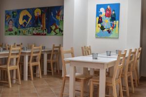 a dining room with tables and chairs and paintings at Al Saliceto Hotel in Patti