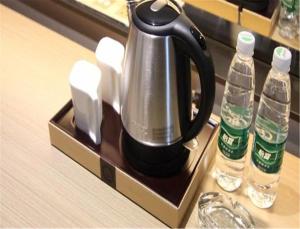 a tea kettle on a tray next to two water bottles at Foshan Lavande Kuiqi Road Subway Station in Foshan