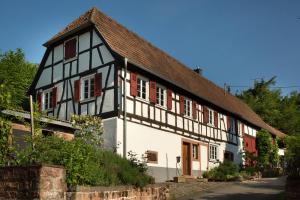 an old black and white building with red windows at Feriengaleriewohnung Im Denkmal Stilvoll-Komfortabel Baubiologisch in Erlenbach