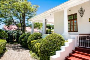 una casa blanca con setos verdes en 5 Camp Street Guesthouse & Self-catering, en Ciudad del Cabo