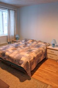 a bedroom with a bed and two tables and a window at Gasthaus Punkaharju in Punkaharju