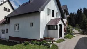 Biały dom z czarnym dachem w obiekcie Apartment and rooms D&J w mieście Žabljak