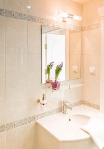 W łazience znajduje się umywalka i lustro. w obiekcie Family Hotel Belle Epoque Beach w Warnie