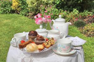 a table with a plate of pastries and tea cups at Mellowvean in St. Agnes