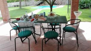 a table with four chairs and a table with food on it at B&B sentiero romantico in Eboli