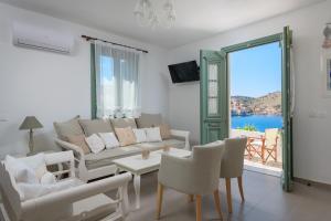 a living room with a couch and a table and chairs at Blue Wave Aigli Villa in Symi