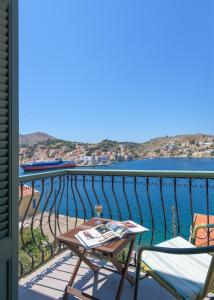 a balcony with a table and chairs and the water at Blue Wave Aigli Villa in Symi