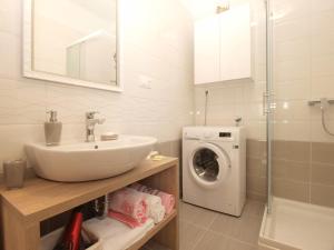 a bathroom with a sink and a washing machine at Apartmenst SLavica 1654 in Ližnjan
