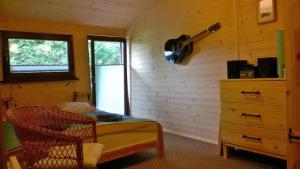 a bedroom with a guitar hanging on the wall at Bory Tucholskie Domek in Skorzenno