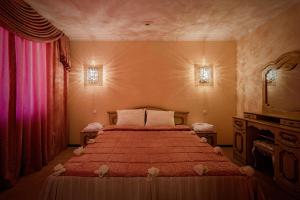 a bedroom with a bed with a red comforter at Pyatigorsk Hotel in Pyatigorsk