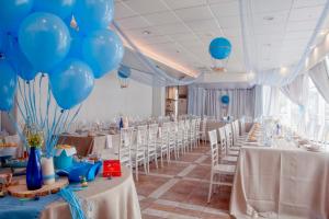 a banquet hall with white tables and blue balloons at Hotel Spa El Muelle de Suances in Suances +120 photos