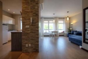 a kitchen and a living room with a blue couch at Apartamenty Starówka - Riverside II in Szczecin
