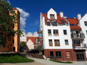 duży biały budynek z czerwonym dachem w obiekcie Apartamenty Starówka - Riverside II w Szczecinie