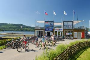 a group of people riding bikes down a road at Apartmán Lipno 50/18 in Lipno nad Vltavou