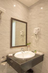 a bathroom with a sink and a mirror at Vy House in Hanoi