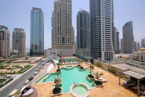 a large swimming pool in a city with tall buildings at Icon Casa Living - Trident Grand Residence in Dubai