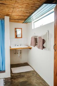 La salle de bains est pourvue d'un lavabo et d'un miroir. dans l'établissement De Bos Cottages, à Montagu