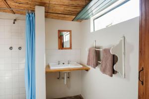 La salle de bains est pourvue d'un lavabo et d'un miroir. dans l'établissement De Bos Cottages, à Montagu