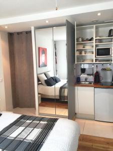 ein Schlafzimmer mit einem Bett und eine Küche in einem Zimmer in der Unterkunft Au Cœur des Remparts in Aigues-Mortes
