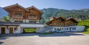 un grand bâtiment avec une voiture garée devant lui dans l'établissement Alpenchalet Brücke, à Mayrhofen