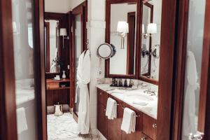 a bathroom with a mirror and a sink at Hotel Schloss Mönchstein in Salzburg