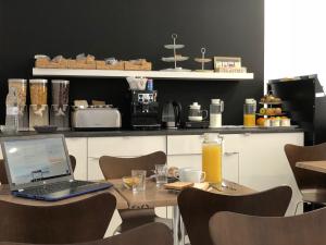 laptopa siedzącego na stole z krzesłami w obiekcie Bed&Breakfast 10 GIRONA w mieście Girona