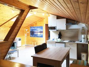 cocina con techo de madera y mesa de madera en Karawanken Lodge, en Faak am See