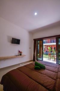 uma cama grande em um quarto com uma janela grande em Ratna Guest House em Ubud