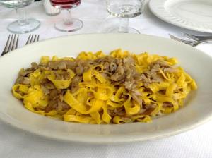 un plato de pasta con carne y queso en una mesa en Acquacheta Valtancoli, en San Benedetto in Alpe