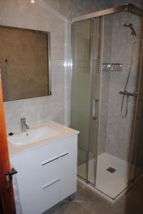 W łazience znajduje się umywalka i prysznic ze szklanymi drzwiami. w obiekcie Apartaments el tiet w mieście Sant Carles de la Ràpita +19 zdjęć