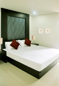 een slaapkamer met een groot wit bed met rode kussens bij DB Plus 3 in Bangkok