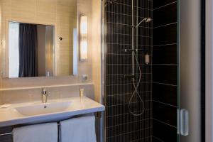 a bathroom with a sink and a shower at Best Western Plus Richelieu in Limoges