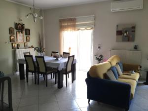 ein Wohnzimmer mit einem Tisch, Stühlen und einem Sofa in der Unterkunft Chalkida Beautiful Home with Stunning Views in Chalkida