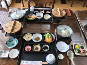 田邊的住宿－龍津溫泉丸井旅館，一张桌子上放着几盘食物