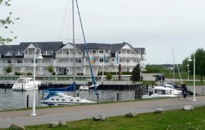 a man riding a bike next to a marina with boats at Wohnen am Yachthafen in Ostseebad Karlshagen