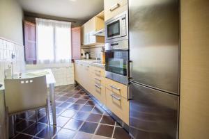 a kitchen with a stainless steel refrigerator and a sink at Buga II in Posada de Llanes