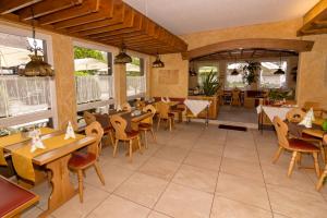 赫興斯旺德的住宿－科提納酒店，餐厅设有木桌、椅子和窗户。